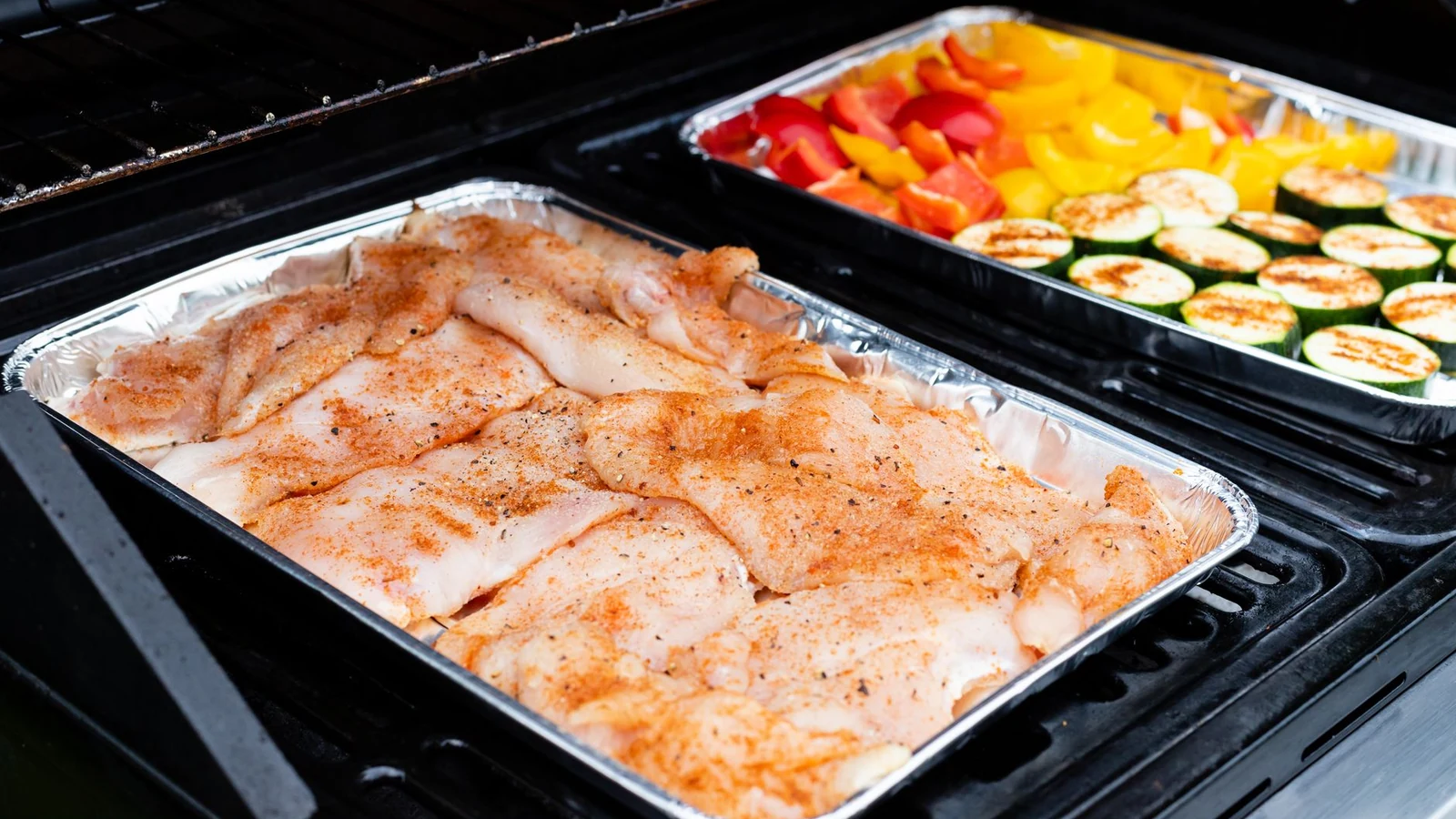 Raw seasoned chicken and vegetables laid out ready to cook