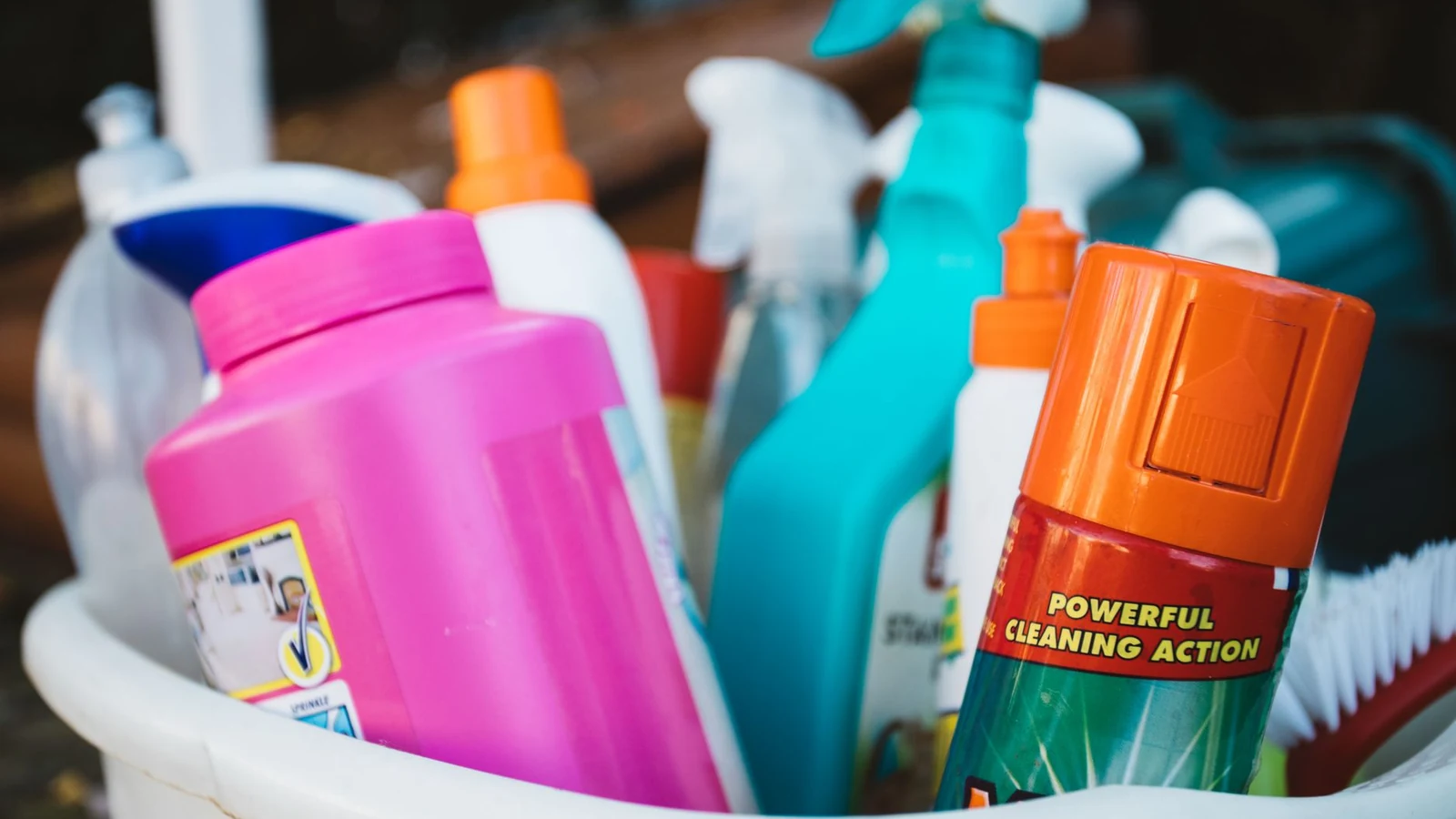 A caddy overflowing with cleaning bottles and a brush